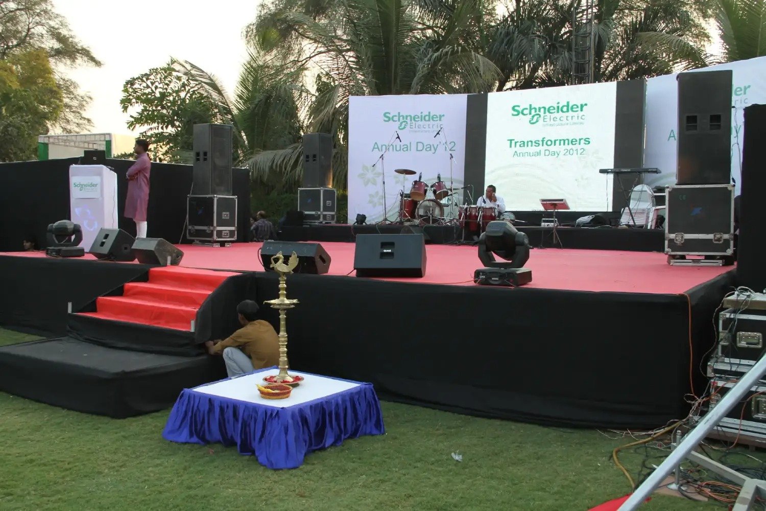 Man and woman speaking on stage at night with blue lighting